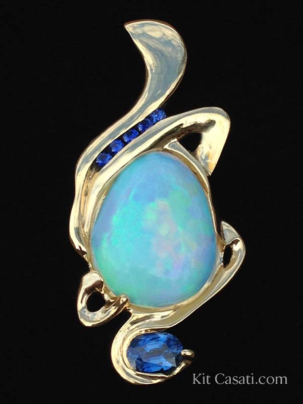 8 ct. Ethiopian opal with blue sapphires, in 14k yellow gold. By Kit Casati.